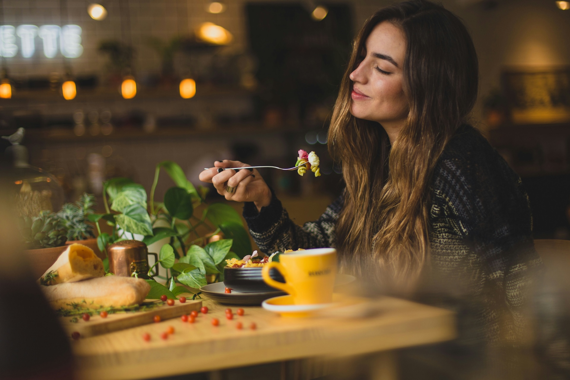 Woman smiles while eating pasta