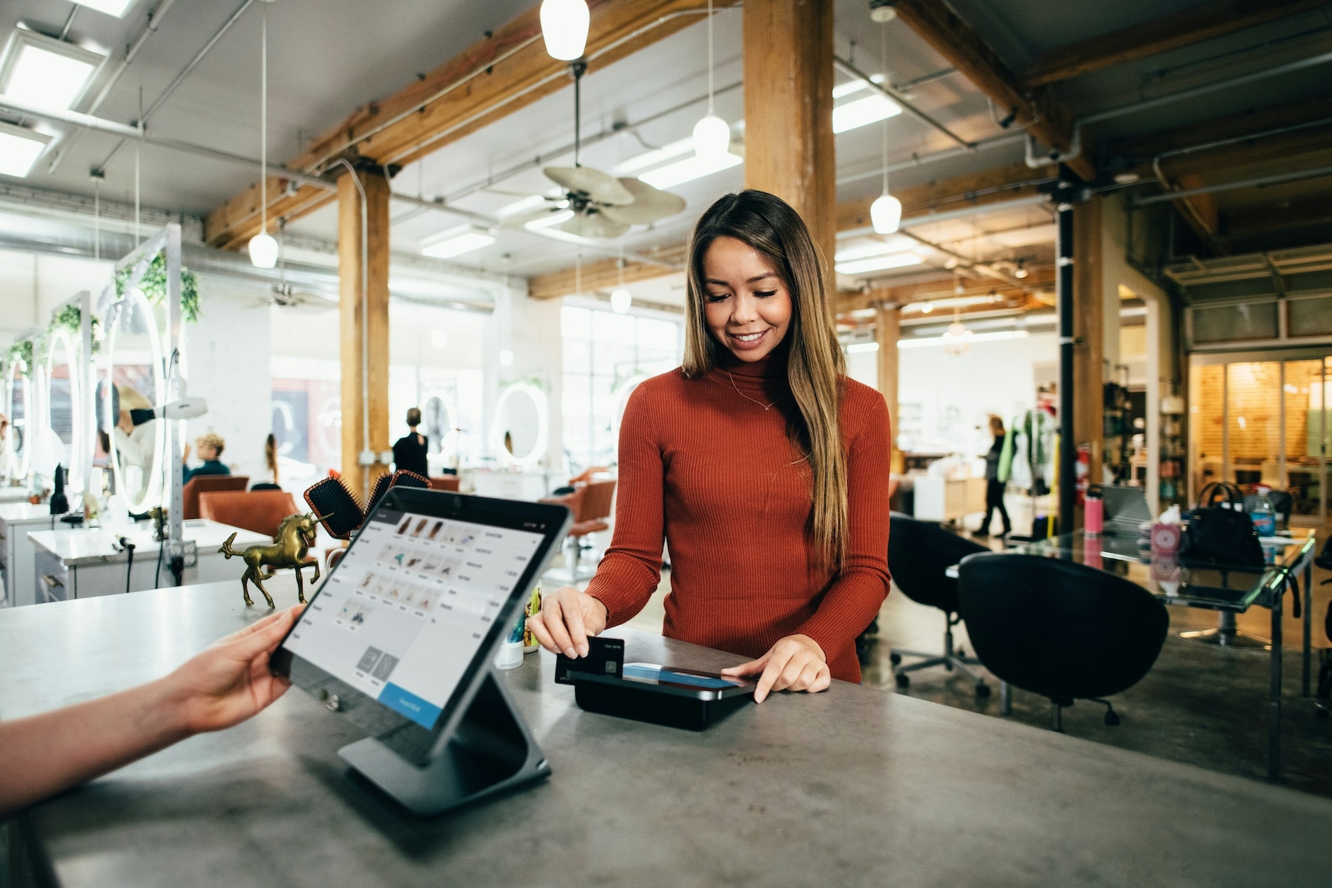 Woman uses a POS system to pay at a restaurant