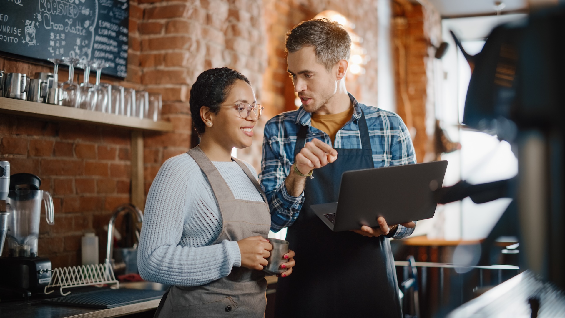 Two Diverse Entrepreneurs Have a Team Meeting in Their Stylish Coffee Shop