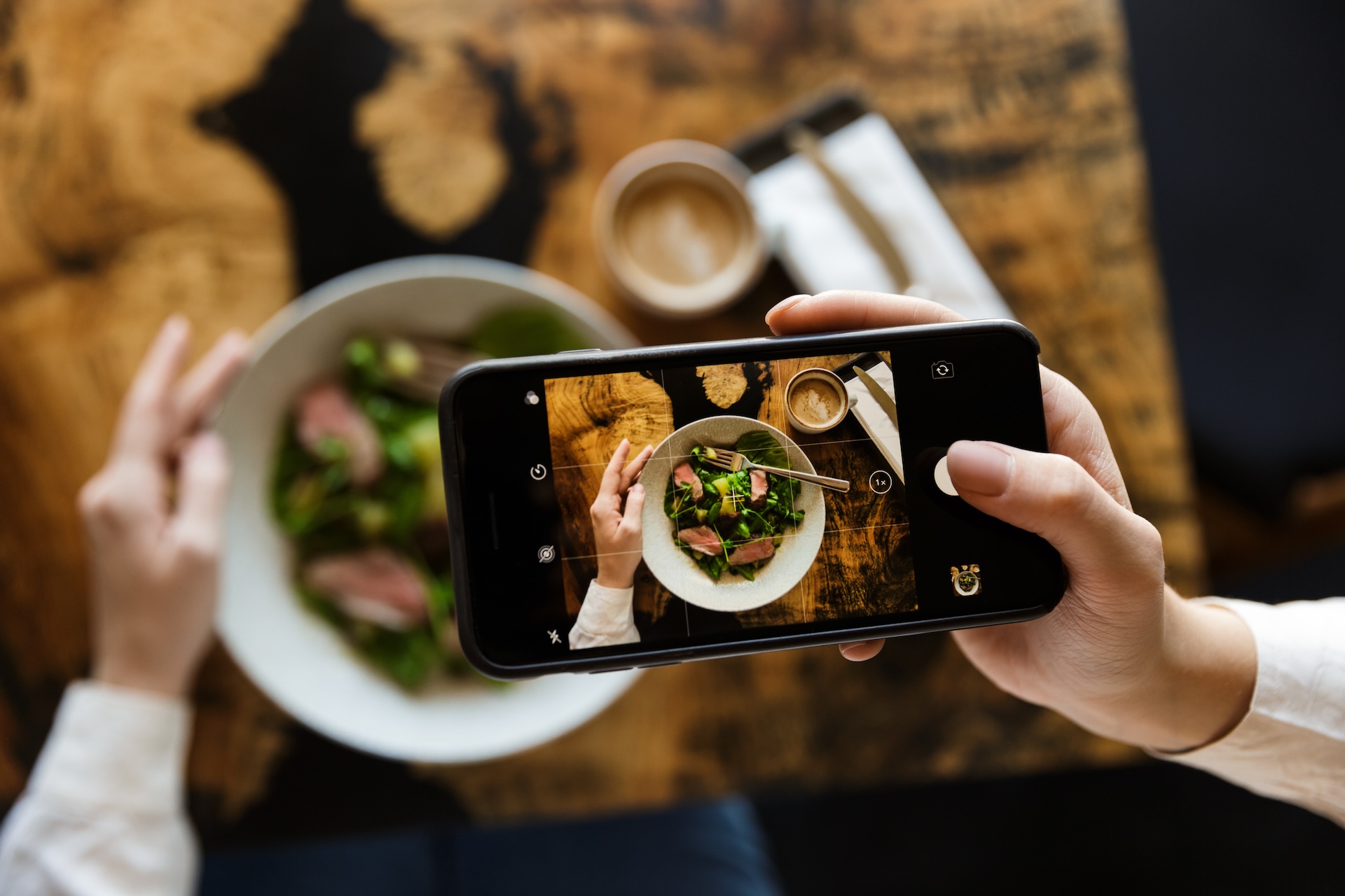 Woman taking a picture of her lunch to market the restaurant