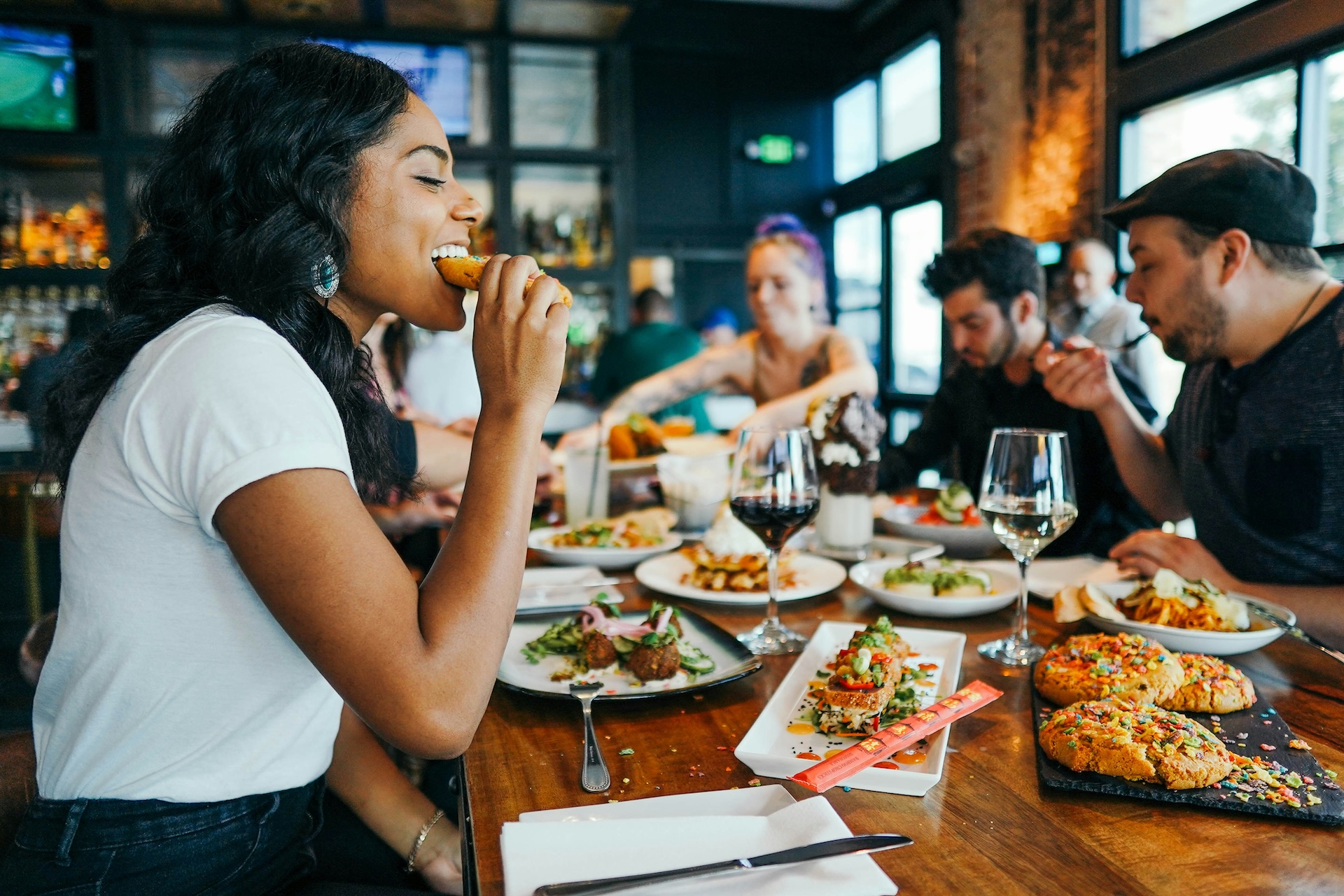 woman in white shirt eating at a themed event at a restaurant