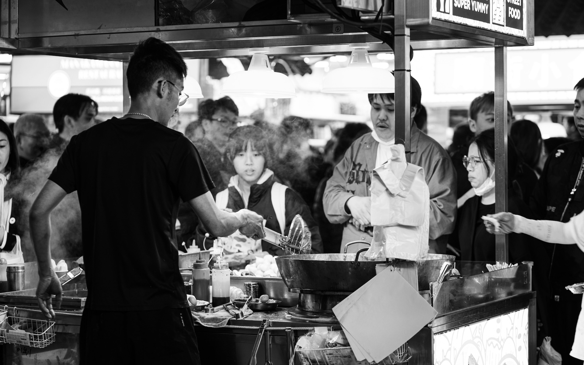 people standing around a food stand marketing a restaurant