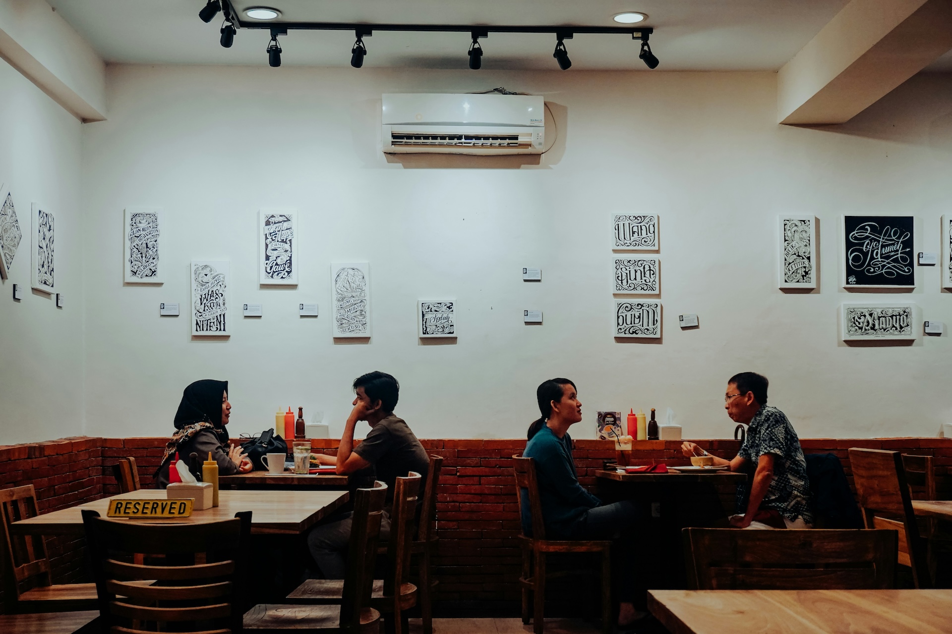 people sitting inside a restaurant with local artworks