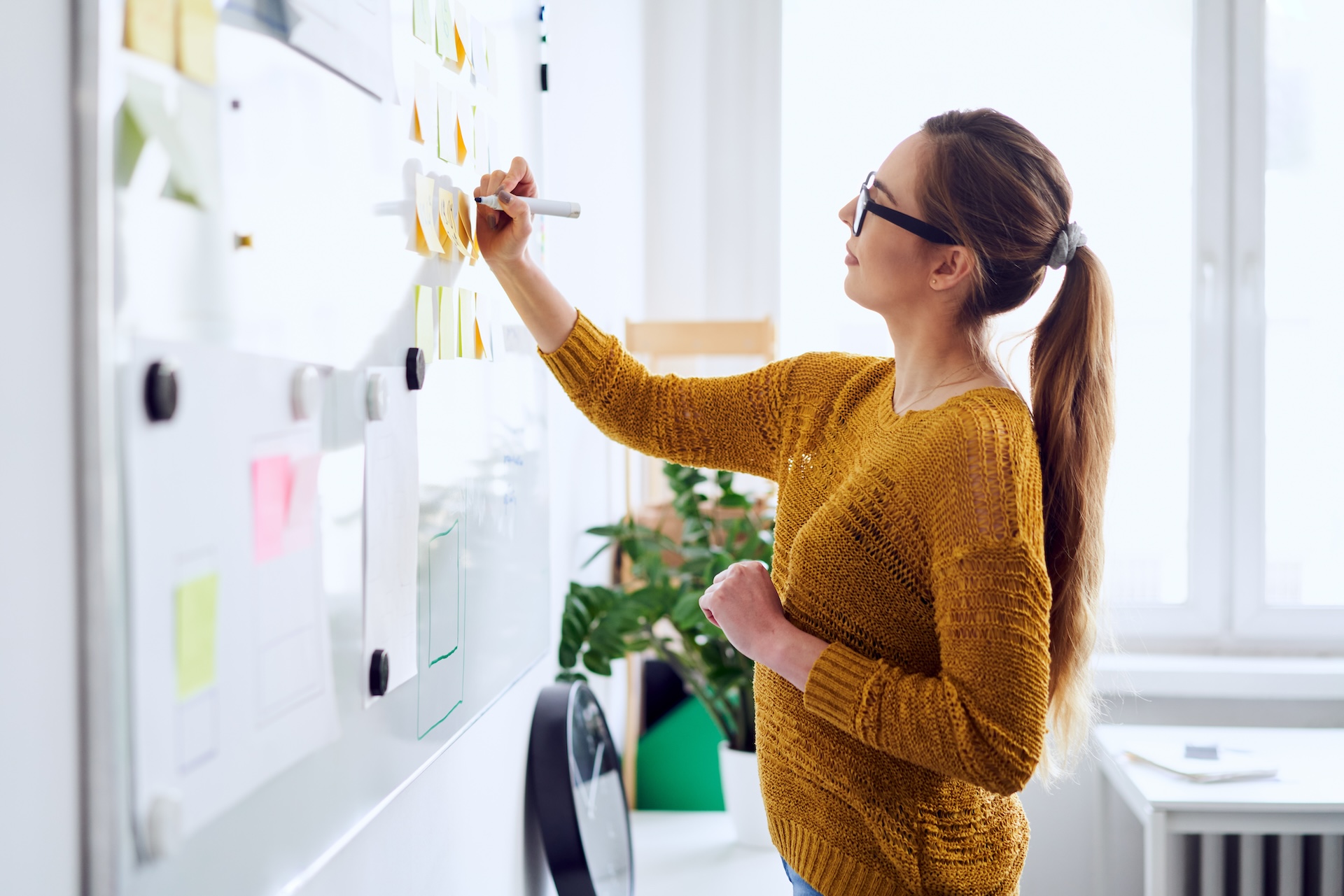 Young businesswoman creating an event planning template on whiteboard