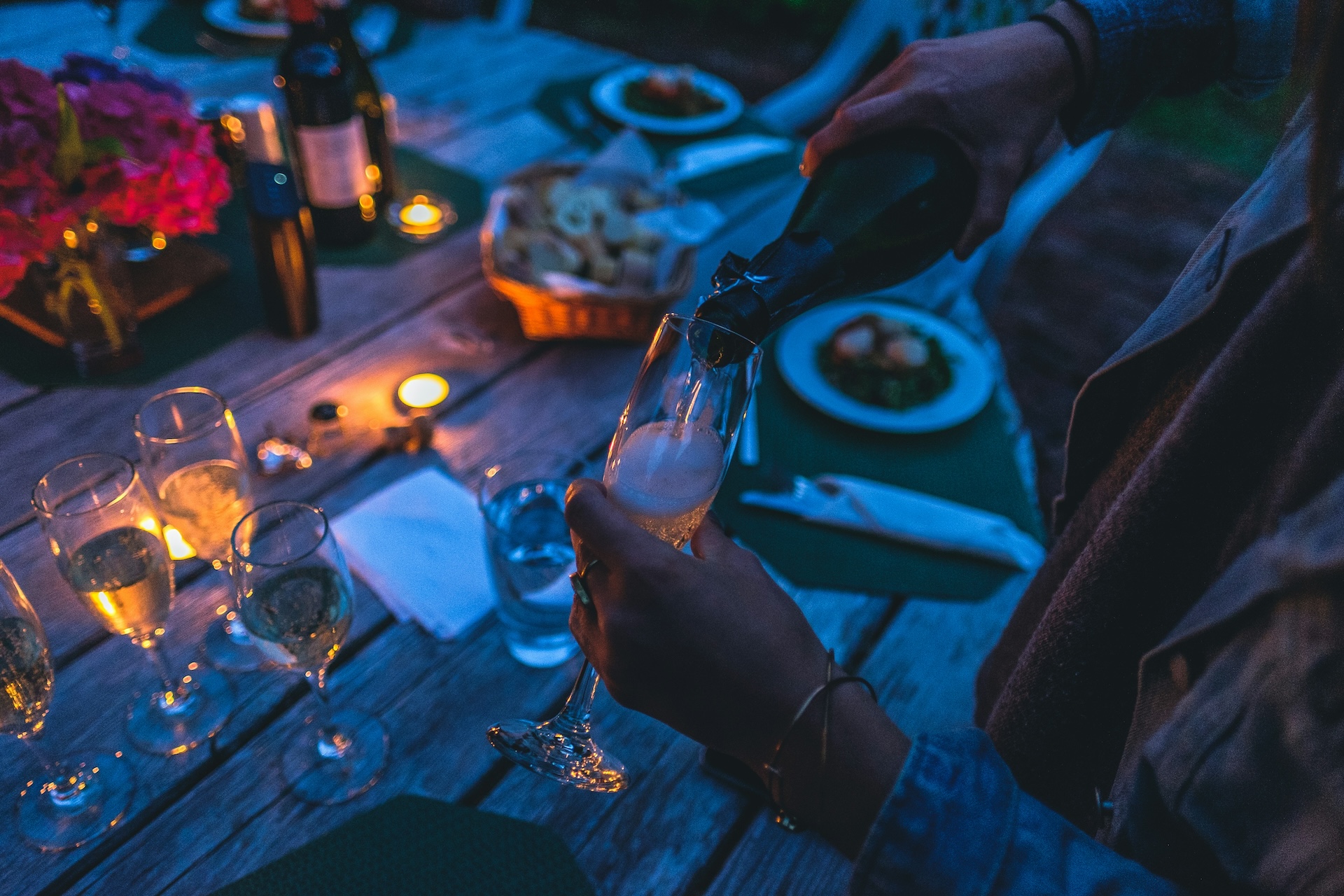 person pouring champagne in a flute glass