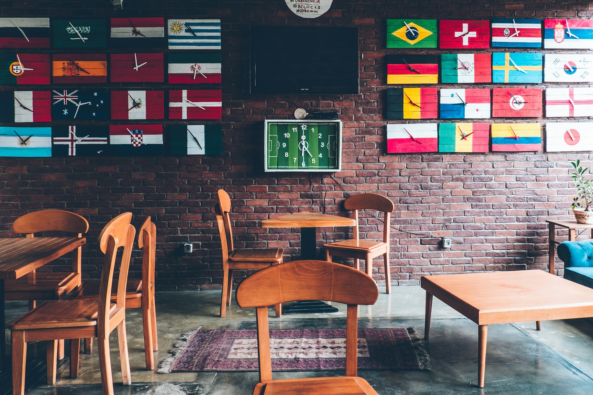 sports bar decorated with clocks that have european flags as faces