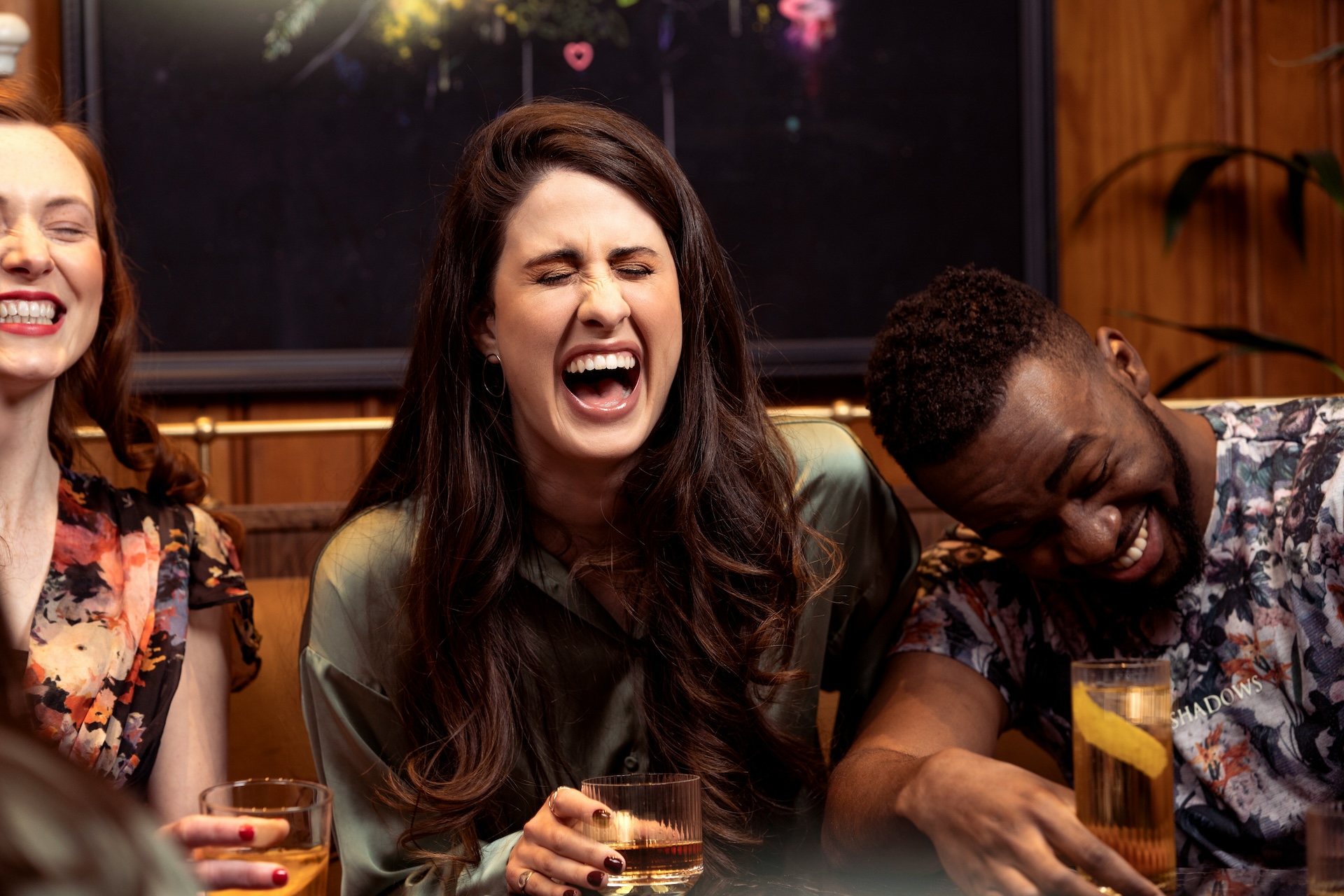 three friends laughing at a bar