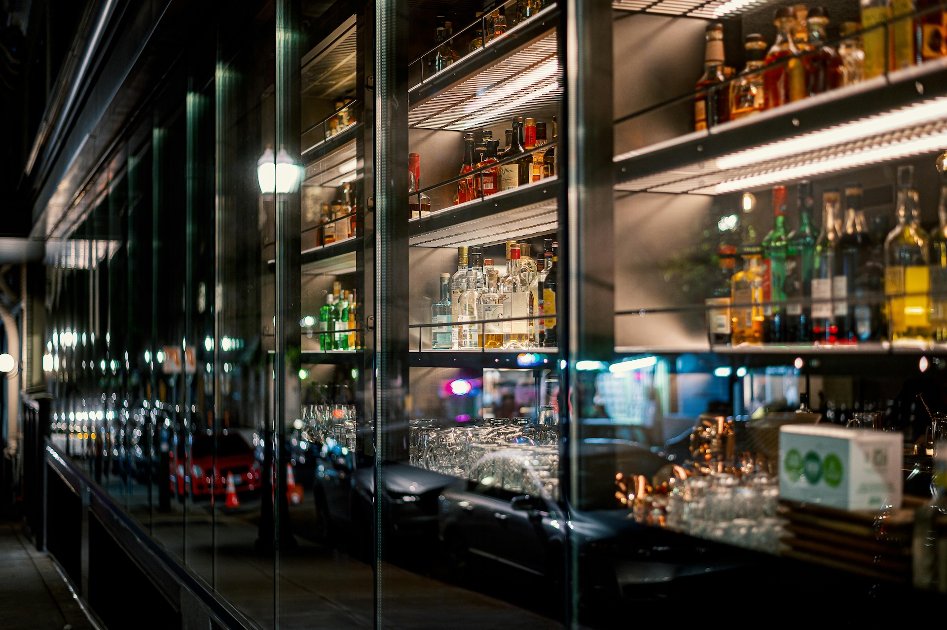 shelves of glass bottles behind a cabinet