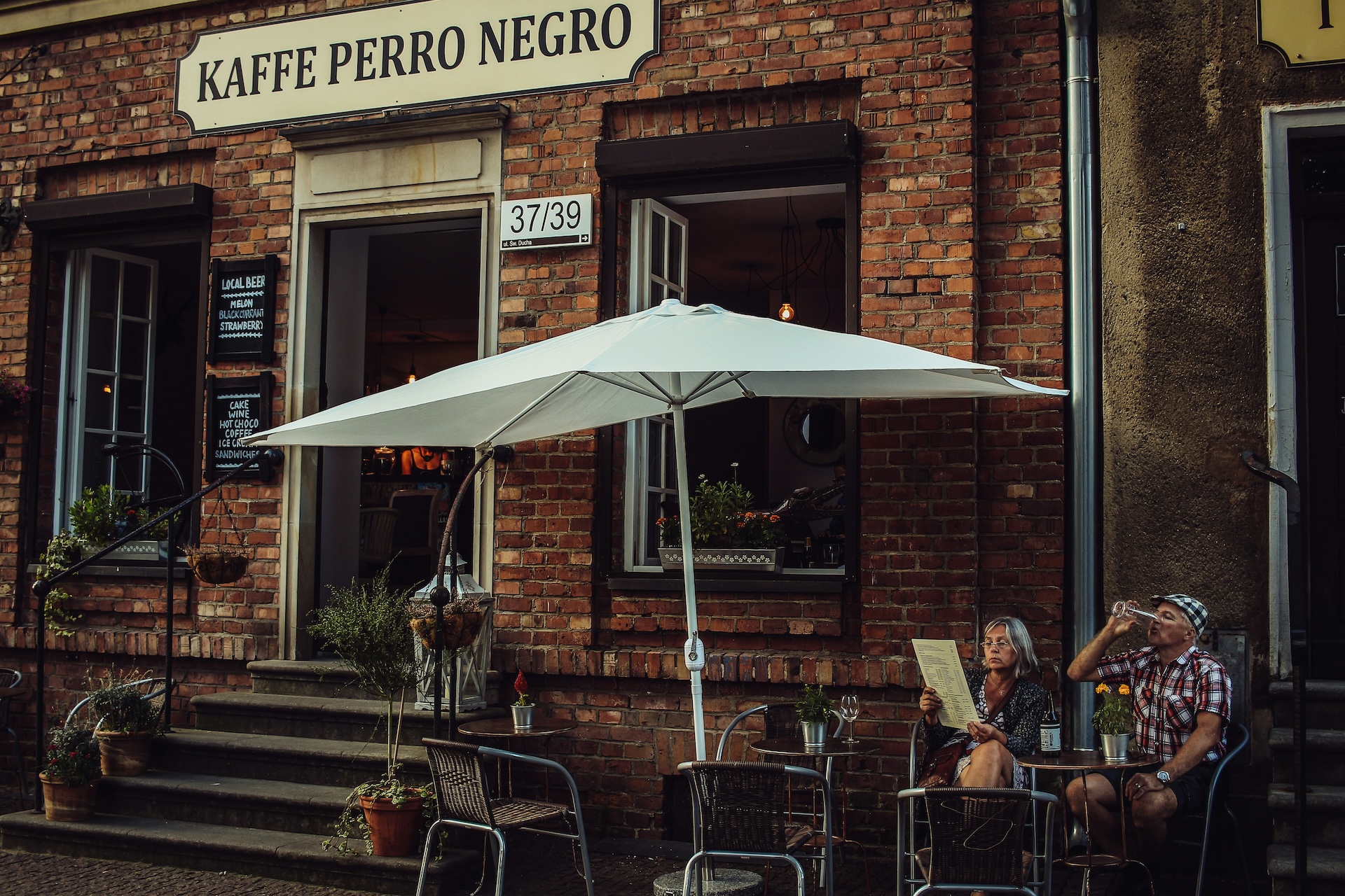 man and woman sit outside european bar