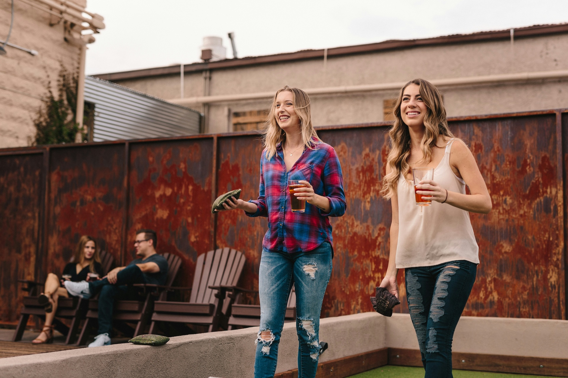 two friends playing bar games beanbag toss