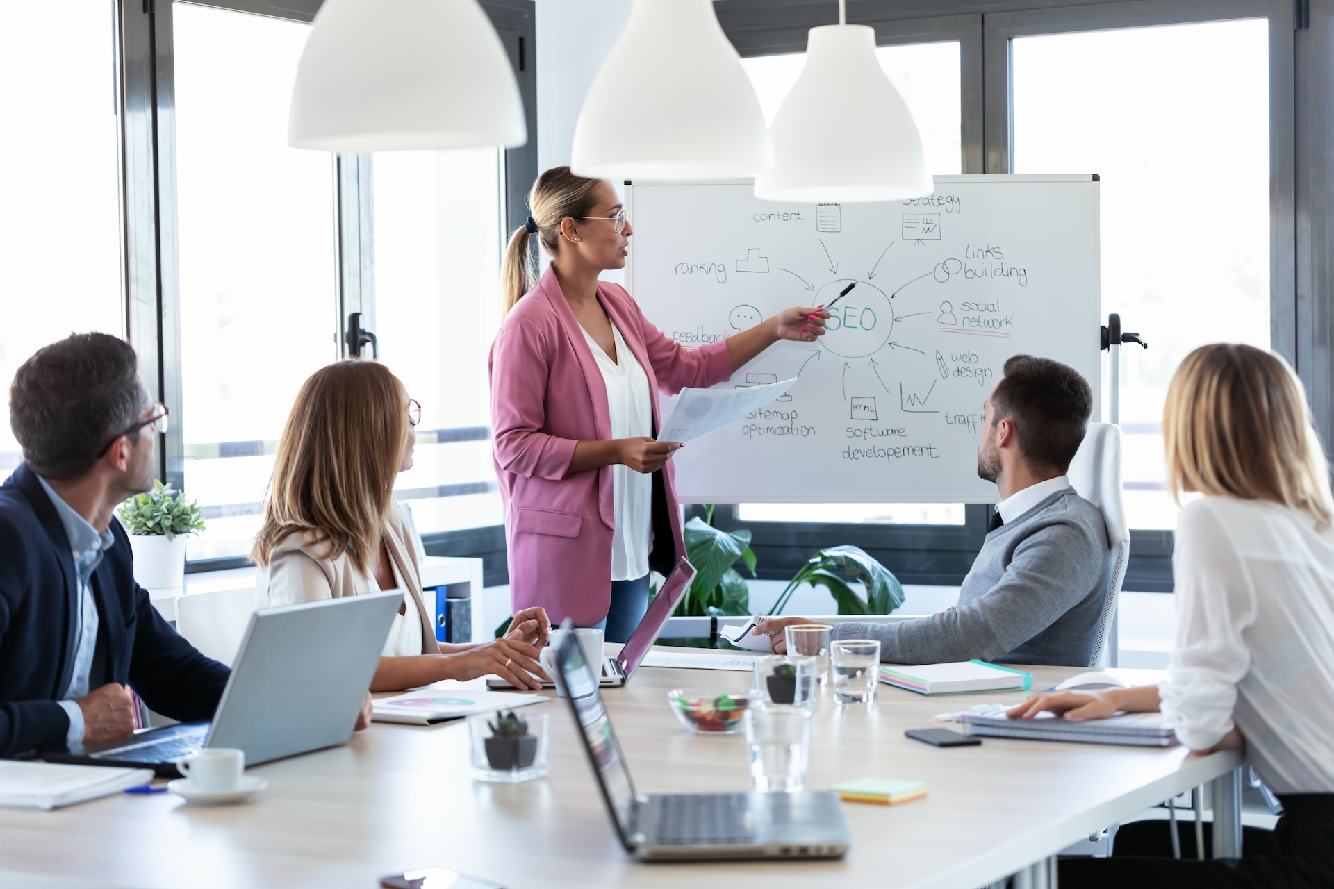 businesswoman pointing at white blackboard explaining to restaurant marketing agency