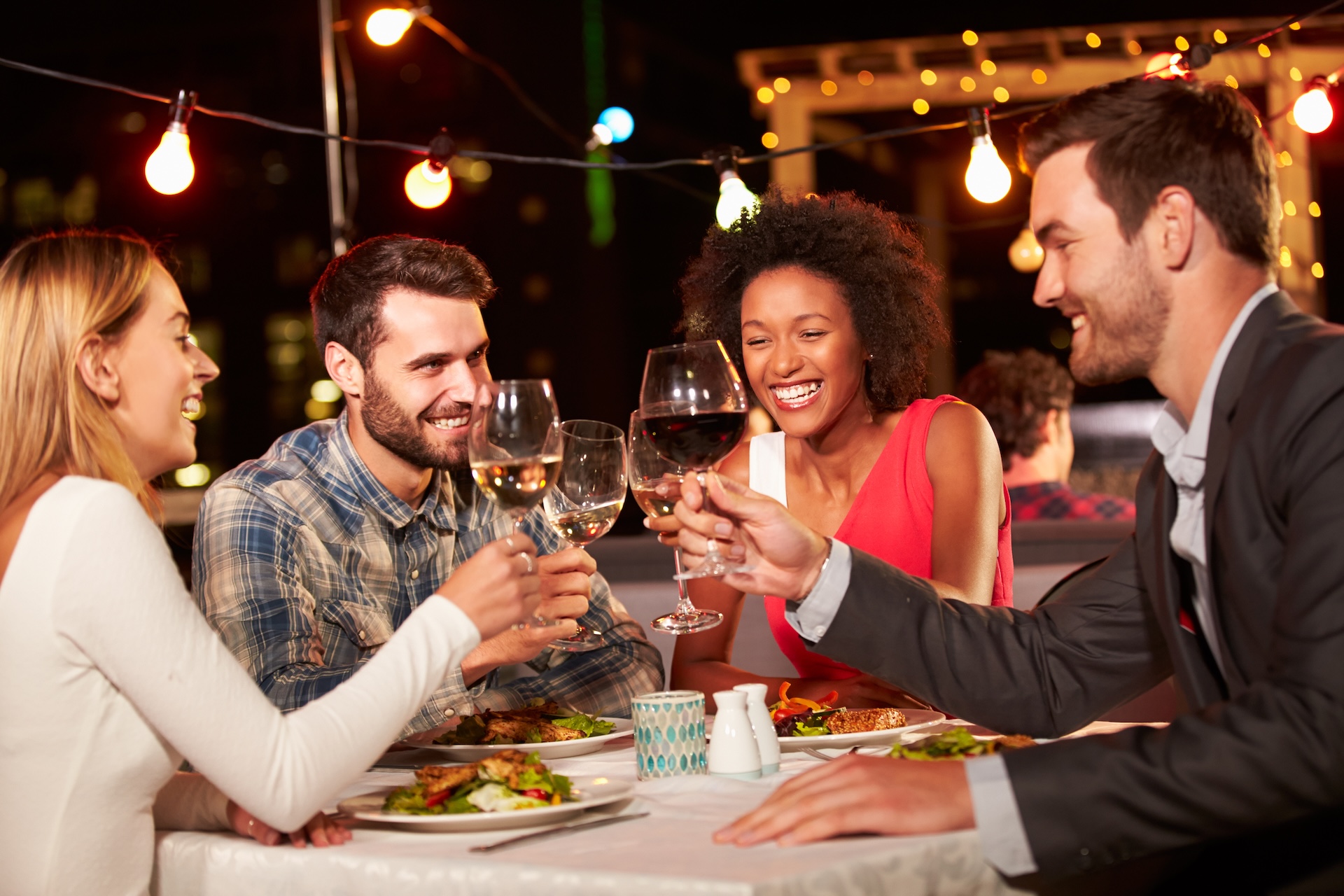 Four friends eating dinner at wine bar