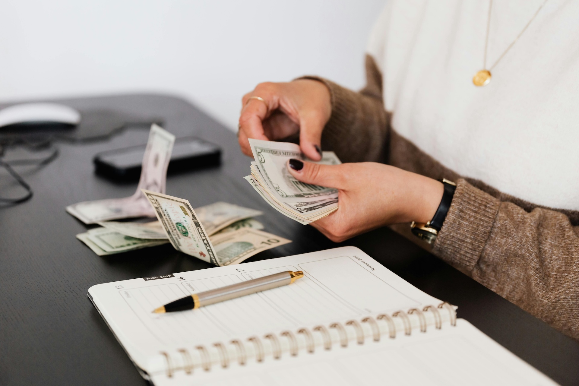 person counting out cash for one of the functions of financial management