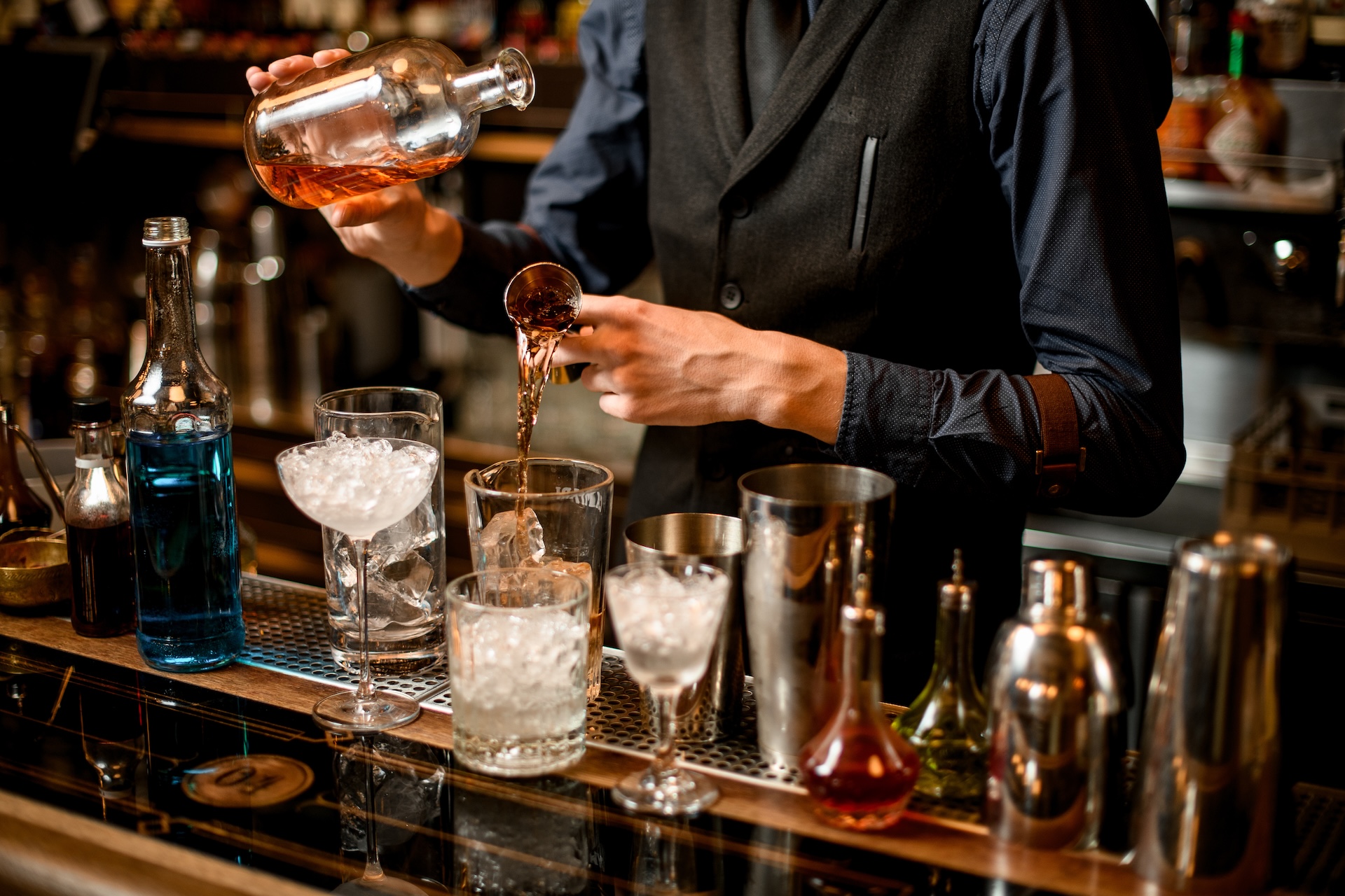 Professional bartender cook alcoholic cocktail with ice