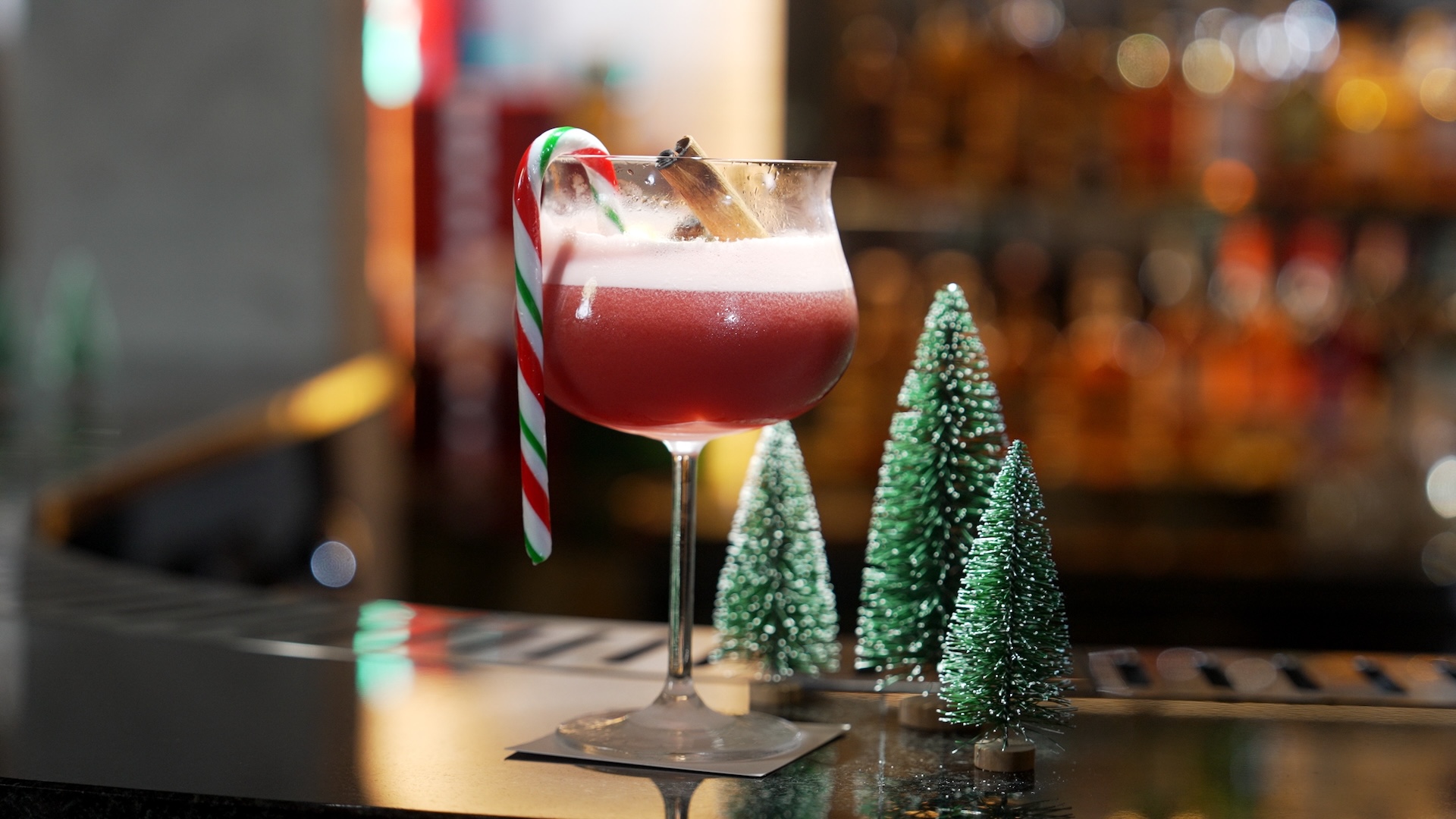 cocktail christmas theme garnished with candy cane and cinnamon